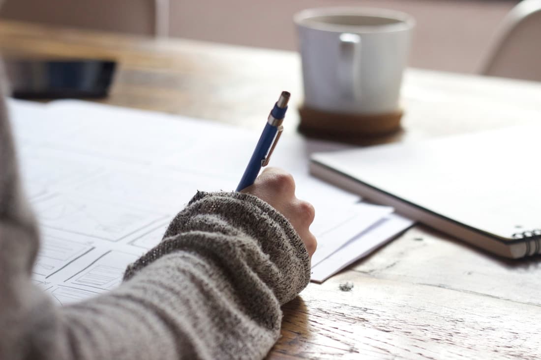A student studying at a desk, focused on academic work.